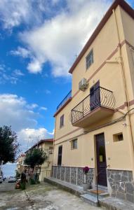a yellow building with a balcony and a blue sky at La Dependance ApartHotel Scilla in Scilla