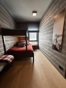 1 dormitorio con 1 cama en una habitación con suelo de madera en Eksklusiv og moderne leilighet, en Beitostølen