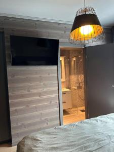 1 dormitorio con cama, espejo y luz en Eksklusiv og moderne leilighet, en Beitostølen