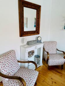 a living room with two chairs and a mirror at Twin Pines Apartment in Egerszalók