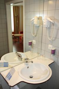 a bathroom with a sink and a mirror at Hotel De la Paix in Lucerne