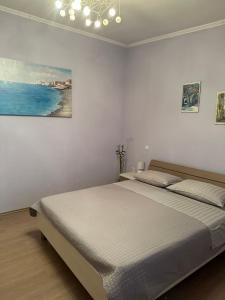 1 dormitorio con 1 cama con una pintura en la pared en Apartment Kosović, en Dubrovnik