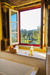 een badkamer met een raam met een fruitmand op een aanrecht bij Casa do Ribeiro in Lago