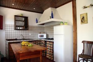 a kitchen with a wooden table and a white refrigerator at Casa Rural Tía ilia in Puntallana