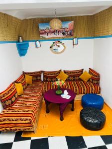 un soggiorno con divano e tavolo di Dar Beldi a Marrakech