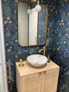 a bathroom with a sink and a mirror at Chez Gaston, les gîtes de cazes in Sérignac