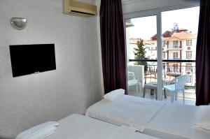 シダにあるSaygılı Beach Hotelのベッド2台とバルコニーが備わるホテルルームです。