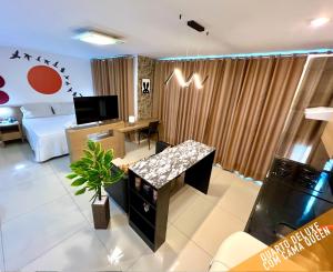 a living room with a bed and a tv in it at Verano Stay Flat Barra Olímpica in Rio de Janeiro