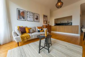 FLH Funchal Urban Escape Flat في فونشال: غرفة معيشة مع أريكة وطاولة