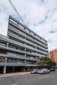 un gran edificio con coches estacionados frente a él en Felix Frías 108 B General Paz Edificio con Pileta en Córdoba