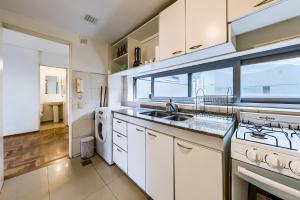 cocina con armarios blancos, fregadero y ventana en Felix Frías 108 B General Paz Edificio con Pileta en Córdoba