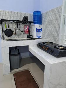 a kitchen counter with a sink and a stove at HOMESTAY PANDAN in Halangan