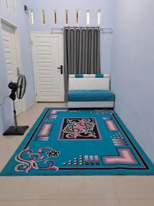 Habitación con cama y alfombra en el suelo en HOMESTAY PANDAN en Halangan