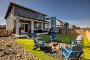 een tuin met blauwe stoelen en een huis bij Bridge House in Ocean Shores