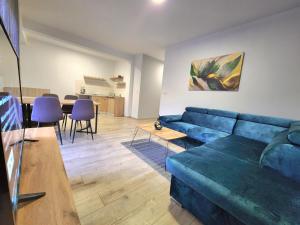 a living room with a blue couch and a table at Residence Riverside in Mostar