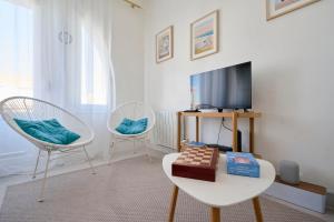 een woonkamer met een tv en 2 stoelen bij Superbe appartement, balcon vue mer, 3 chambres! in Bray-Dunes