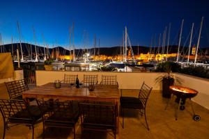 a wooden table and chairs on a balcony with a marina at Apartman Ciciliani in Trogir