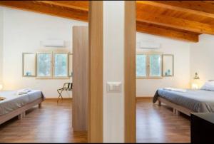 a bedroom with two beds in a room with wooden ceilings at Casale Carolea in Sarrotino