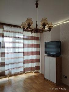 a living room with a television and a chandelier at Graz-Apartments 01 in Graz