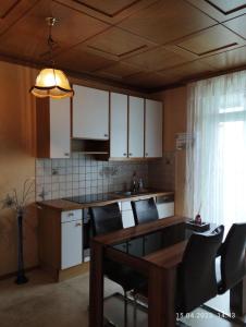 a kitchen with white cabinets and a table and chairs at Graz-Apartments 01 in Graz