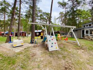 a playground with a swing set in a yard at Domki U Huberta Międzywodzie in Międzywodzie