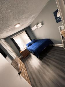 a bedroom with a blue bed and a window at THE BUNGALOW in Atlantic City