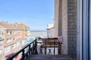 uma varanda com um banco e vista para a praia em Superbe appartement, balcon vue mer, 3 chambres! em Bray-Dunes