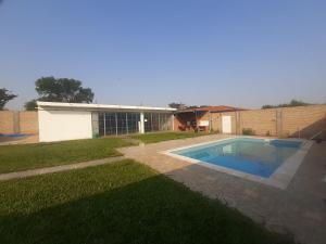 a yard with a swimming pool in front of a house at ALOJAMIENTO ASPEN HOME in San Lorenzo de la Frontera