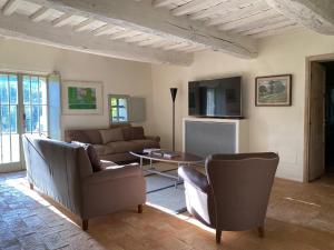 a living room with a couch and chairs and a table at L'ocanda Rancioli in San Casciano dei Bagni