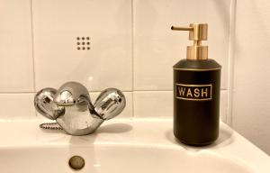 uma garrafa de sabão preta sentada no lavatório da casa de banho em The Comfy Flat- Modern & Bright 2 Bedrooms Apartment em Liverpool