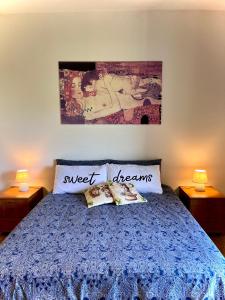 a bedroom with a blue bed with two pillows at Ambrazzurra Apartament in Aci Castello
