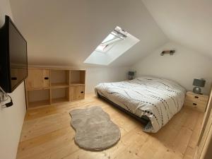 a bedroom with a bed and a skylight at Chez Mongery in Landreville