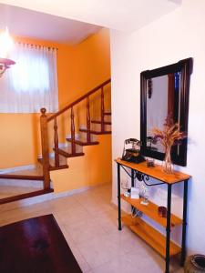 uma sala de estar com uma escada e um espelho em La casa de Isabel em Mazo