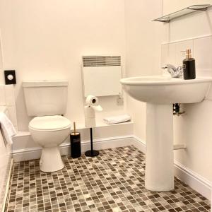 uma casa de banho com um WC branco e um lavatório. em The Comfy Flat- Modern & Bright 2 Bedrooms Apartment em Liverpool