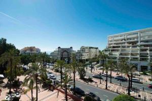 vistas a una ciudad con palmeras y edificios en PUERTO BANUS, 2 ROOMS, POOL AND PRIVATE PARKING., en Marbella