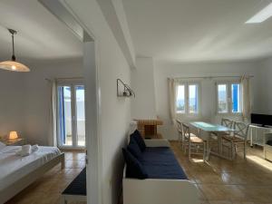 a bedroom with a bed and a dining room with a table at Villa Maniati Studios in ayios Petros