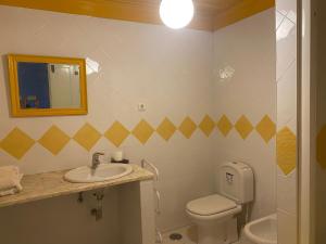 uma casa de banho com um lavatório, um WC e um espelho. em Casa da Ponte, Coja em Coimbra