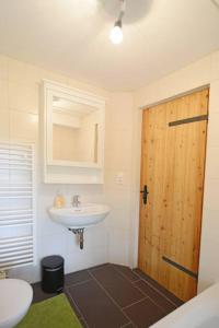 ein Badezimmer mit einem Waschbecken und einer Holztür in der Unterkunft traumhaftes Haus in idyllischer Lage 