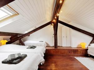 2 camas en una habitación con techo con luces en La Diligence, gîte de caractère au cœur d'Arbois, en Arbois