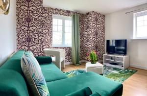 リバプールにあるThe Comfy Flat- Modern & Bright 2 Bedrooms Apartmentのリビングルーム(緑のソファ、テレビ付)
