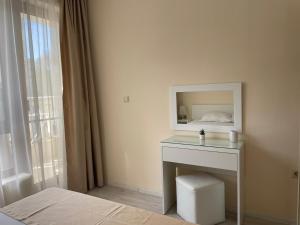 a bedroom with a bed and a table with a mirror at Deluxe Apartment Varna South Bay Beach Residence in Varna City