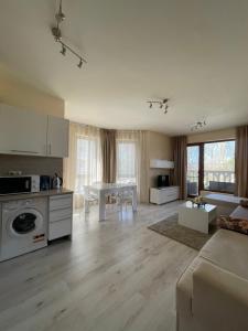 a living room with a kitchen and a dining room at Deluxe Apartment Varna South Bay Beach Residence in Varna City