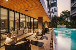 a swimming pool next to a building with chairs and a swimming pool at Cascade Hotel Bangkok in Bangkok