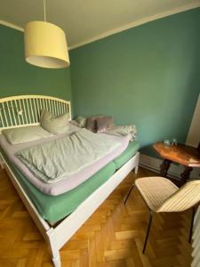 a bed in a room with a table and a chair at geräumiges 120m² Haus mit Garten + Stellplatz in Stralsund