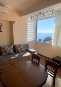- un salon avec un canapé, une table et une fenêtre dans l'établissement Apartment Kosović, à Dubrovnik