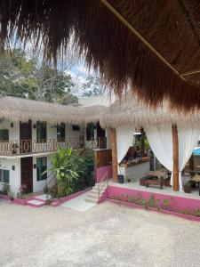 um resort com um edifício com telhado de palha em Hotel Diosa del Agua Bacalar em Bacalar