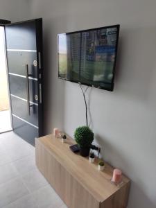 a living room with a tv on a wall at Eleven And A Half apartment in Nea Fokea