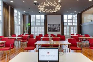 a conference room with tables and red chairs at Hotel Ernst Sillem Hoeve in Den Dolder