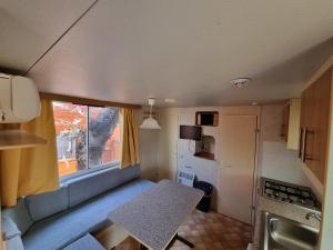 a small kitchen with a table in a caravan at Mobile Home Emma in Lido di Dante
