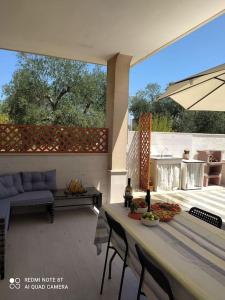 a patio with a table and chairs and a couch at Casa DOLCE PUGLIA Melograno in Castellana Grotte